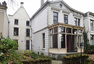 <p>Het exterieur van het achterhuis uit 1882 werd in eclectische stijl vormgegeven. De serre moet volgens de kadastrale hulpkaart kort voor 1907 gebouwd zijn. Waarschijnlijk is in de vroege 20ste eeuw ook de blokbepleistering aangebracht op de achtergevel van het rechter huis (de tuitgevel links op de foto). Ook de roedeverdeling van de vensters in deze gevel werd gewijzigd. </p>
